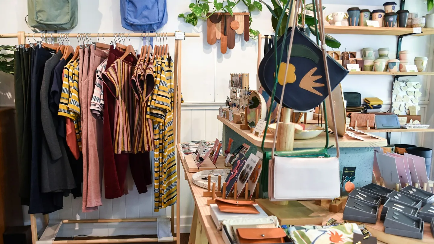 assorted-colored clothes on rack near brown wooden table