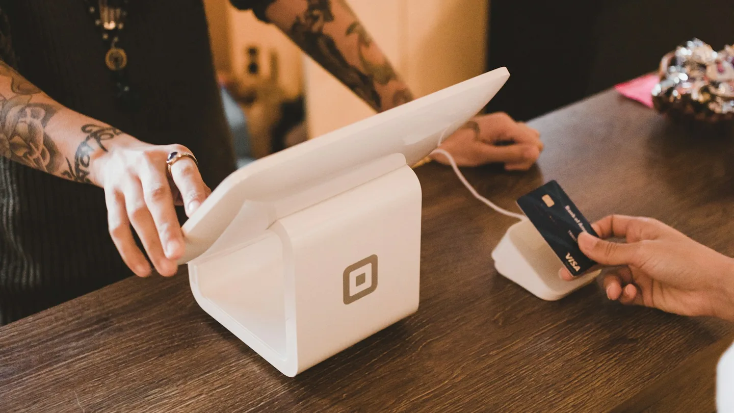 person holding white POS machine