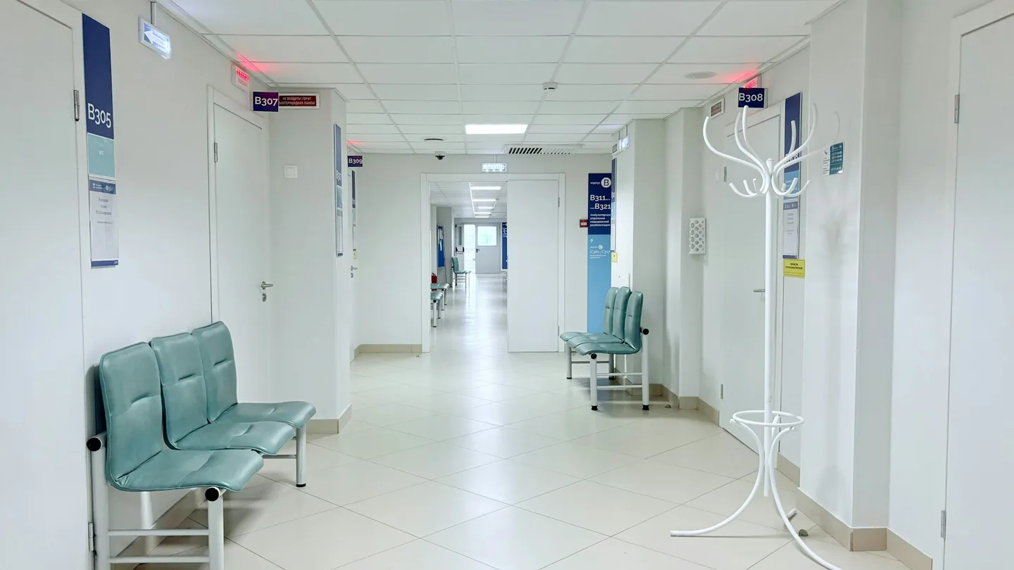 Empty hospital corridor with benches and doors