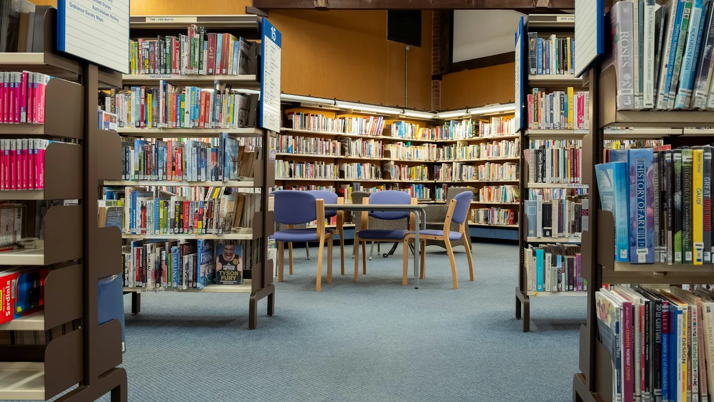 a library filled with lots of books and chairs