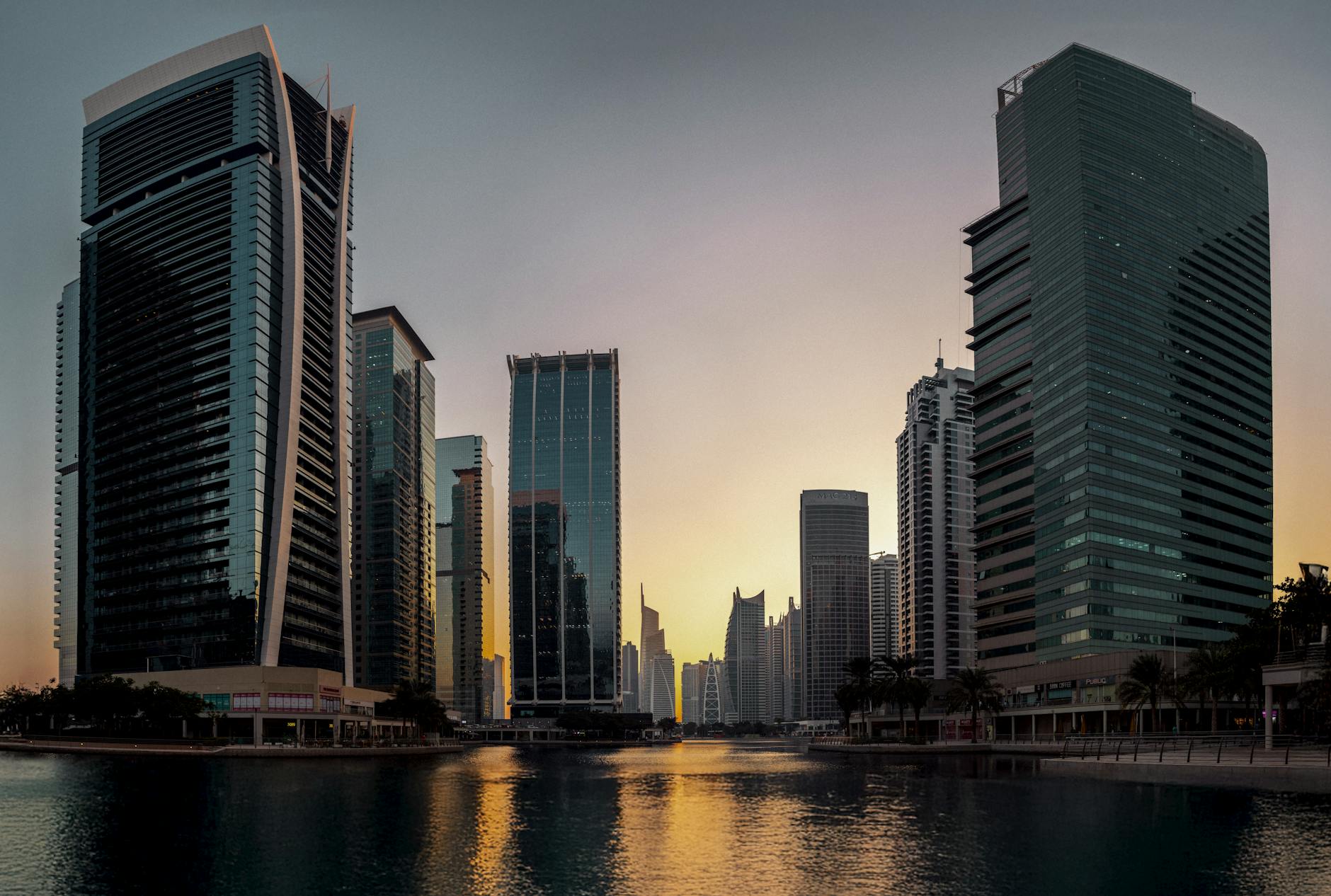Dubai modern skyline at sunset reflecting on water